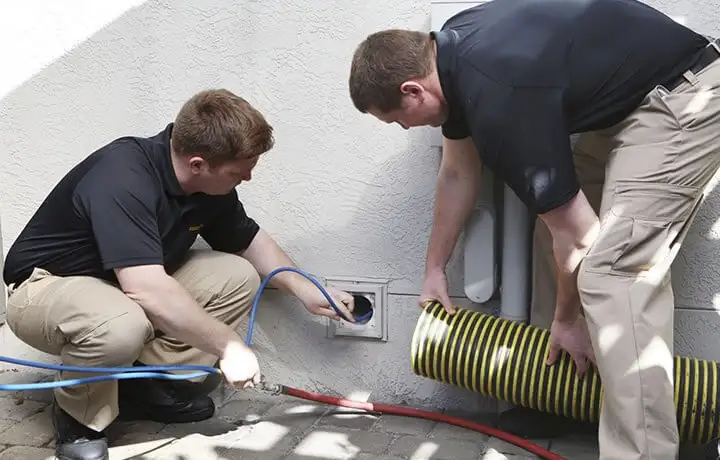 Service technicians cleaning a dryer vent