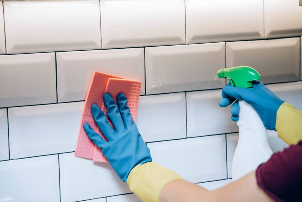 Cleaning service. Woman with gloves cleaning the kitchen. Surface sanitizing.
