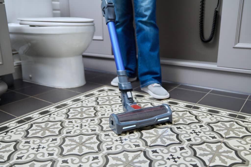 Woman Doing Tile Cleaning with vacuum cleaning